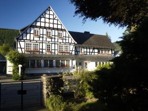 una casa con un edificio en blanco y negro en Pension Gastreich en Lennestadt