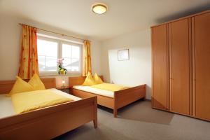 a bedroom with two beds and a window at Appartements Oberhauser in Westendorf