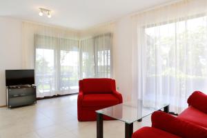 a living room with two red chairs and a glass table at Saint Stefan Villas in Sozopol