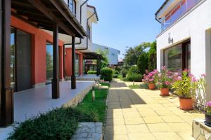 una pasarela entre dos edificios con flores en macetas en Saint Stefan Villas, en Sozopol