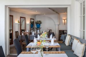 uma sala de jantar com mesas e cadeiras em Hotel Guter Tropfen em Hagnau