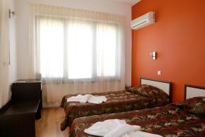 a hotel room with two beds and a window at Saint Stefan Villas in Sozopol +29 photos