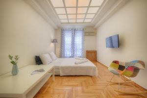 a bedroom with a bed and a table and chairs at Syntagma cozy apartment in Athens
