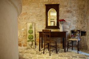 Zimmer aus Stein mit einem Schreibtisch und einem Spiegel in der Unterkunft Nacalino Agriturismo in Modica
