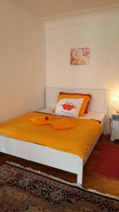 1 dormitorio con 1 cama con manta naranja en Penzion-apartmán U Johana, en Moravská Třebová