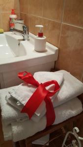 a pile of towels with a red ribbon on a sink at Penzion-apartmán U Johana in Moravská Třebová