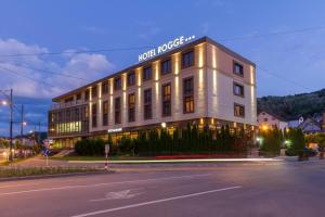 un edificio blanco con un cartel en el costado en Hotel Rogge, en Reşiţa