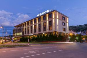 un bâtiment blanc avec un panneau sur son côté dans l'établissement Hotel Rogge, à Reşiţa