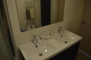 uma casa de banho com um lavatório e um espelho em La Lanterna Apartment em Gênova
