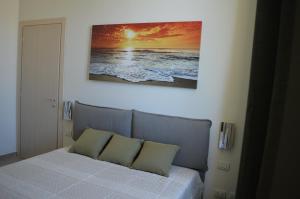 a bedroom with a bed with a picture on the wall at La Lanterna Apartment in Genova