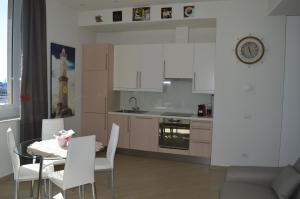 a kitchen with a table and chairs and a dining room at La Lanterna Apartment in Genoa