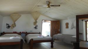 a bedroom with two beds and a ceiling fan at Laguna Blu - Resort Madagascar in Andavadoaka