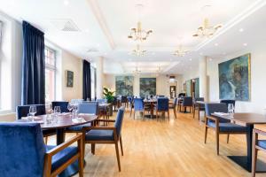 une salle à manger avec des tables et des chaises bleues dans l'établissement Tyssedal Hotel, à Tyssedal