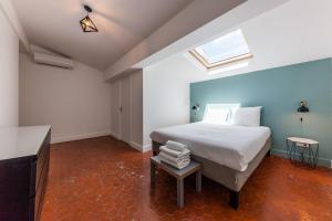 a bedroom with a large white bed and a table at Chez Nous - 7 Appartements sur le Vieux Port in Marseille