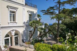 a large white building with a tree in front of it at Luxury Villa Excelsior Parco in Capri