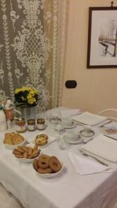 una mesa blanca con platos de comida. en Casa Margherita en Villar San Costanzo