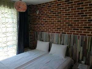 a bed in a room with a brick wall at Studio 11 Plovdiv in Plovdiv