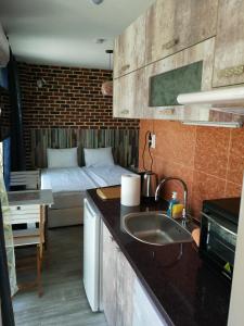 a kitchen with a sink and a bed in a room at Studio 11 Plovdiv in Plovdiv