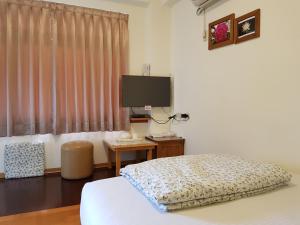 a bedroom with a bed and a flat screen tv at Youran B&B in Jiufen