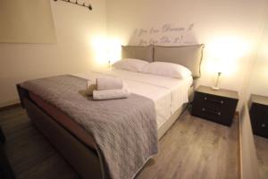 パレルモにあるFirriato di Villafrancaのベッドルーム1室(白いベッドカバー、タオル2枚付)