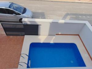 a swimming pool on a balcony with a car in a parking lot at Villa Vistamar in Puerto de Mazarrón
