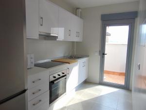a kitchen with white cabinets and a sink and a window at Villa Vistamar in Puerto de Mazarrón