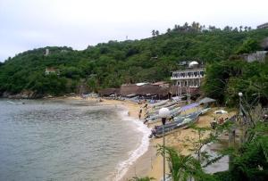 a beach with a group of people and boats on it at Angel del Mar in Puerto Ángel +18 photos