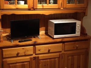 a microwave and a television on a wooden counter at Appartamento Castello Tesino in Castello Tesino