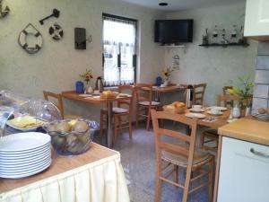 a kitchen with wooden tables and chairs in a room at Pension Weiß in Zinnowitz