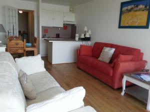 フォール・マオン・プラージュにあるLazyloc - superbe duplex face merのリビングルーム(赤いソファ付)、キッチン