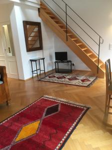 a living room with a staircase and a red rug at Hotel Schloss Storkau in Storkau