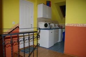 a kitchen with yellow walls and a kitchen with white appliances at Pokoje Gościnne, Kudowa-Słone 62 in Kudowa-Zdrój