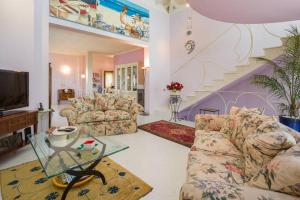 ein Wohnzimmer mit 2 Sofas und einer Treppe in der Unterkunft Villetta Il Glicine in Porto Mantovano