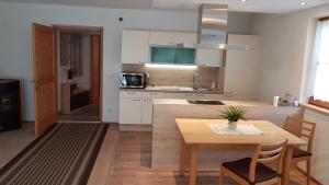 eine Küche und ein Esszimmer mit einem Holztisch in der Unterkunft Bina' s house in Sillian