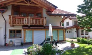 ein Haus mit einer Terrasse und einem Sonnenschirm in der Unterkunft Bina' s house in Sillian