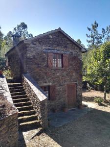 a stone house with stairs leading up to it at Casa da Lomba in Arganil