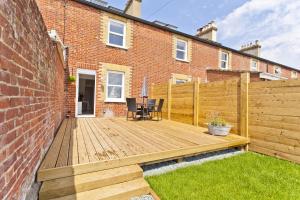 a wooden deck in front of a brick building at Seaside Cottage in Bournemouth