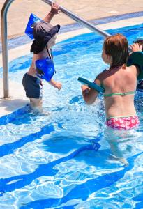 two children are playing in a swimming pool at Hotel Esperia in Marmari