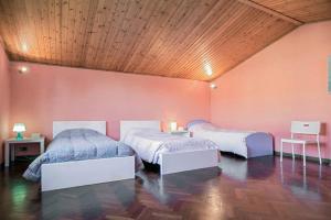 ein Schlafzimmer mit zwei Betten und einer Holzdecke in der Unterkunft Villa Parenti in Lucca