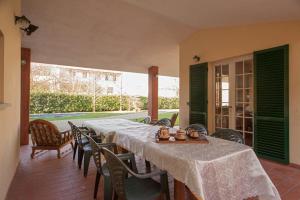ein Esszimmer mit Tischen und Stühlen und einem großen Fenster in der Unterkunft Villa Parenti in Lucca