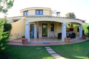 a large yellow house with a large patio at Nuova Valmar Villa Condominio Rei Sole in Costa Rei