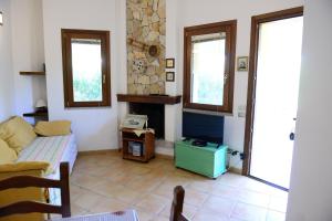 a living room with a couch and a fireplace at Nuova Valmar Villa Condominio Rei Sole in Costa Rei