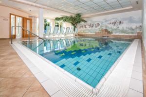una gran piscina con azulejos azules en una casa en Residence Rossboden, en Verano