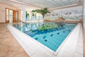 - une grande piscine avec du carrelage bleu dans une maison dans l'établissement Residence Rossboden, à Verano