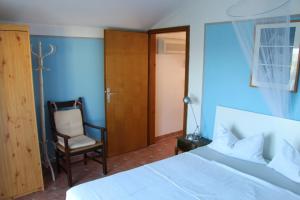 sypialnia z białym łóżkiem i krzesłem w obiekcie Apartment Rosa w mieście Neviđane