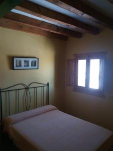 um quarto com uma cama e duas janelas em El Egio em Cervera de Buitrago
