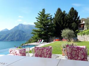 a table and chairs with a view of a lake at Villa Silvi piscina sauna e hot tub in Perledo +49 photos