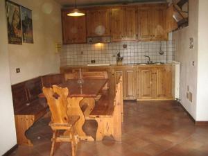 cocina con mesa de madera y armarios de madera en Residence Fontanelle, en Sestola