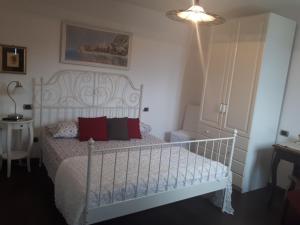 a bedroom with a white bed with red pillows at Villa Silvi piscina sauna e hot tub in Perledo