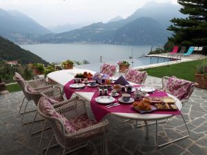 a table with food on it with a view of a lake at Villa Silvi piscina sauna e hot tub in Perledo